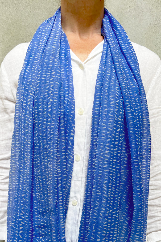 A person wearing a white button-up shirt and See Design's Wool Scarf from Donna Gorman's collection. The head is not visible in the image.