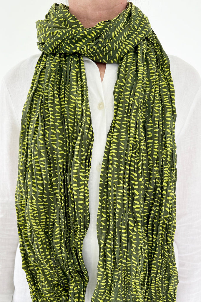 A woman wearing a See Design lightweight cotton scarf.