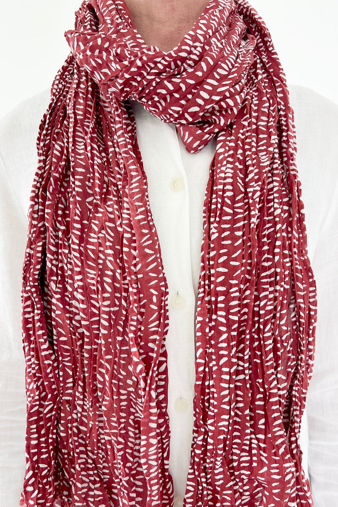 A woman wearing a See Design lightweight cotton scarf.