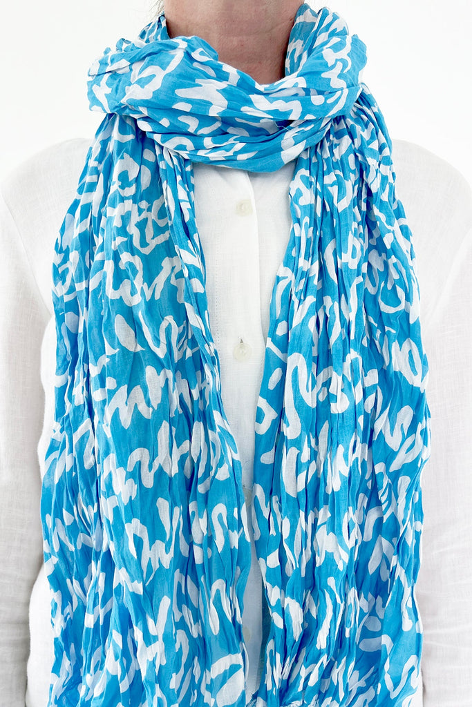 A woman wearing a See Design lightweight cotton scarf.