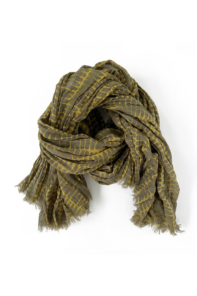 A lightweight See Design green and yellow cotton scarf on a white background.