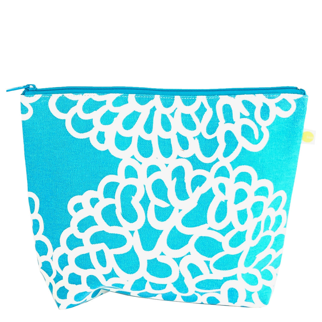 A blue and white Travel Pouch Extra Large with white flowers on it, perfect for travel essentials. Brand: See Design