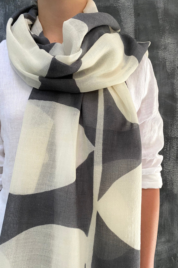 A woman wearing a See Design black and white Wool Scarf accessory.