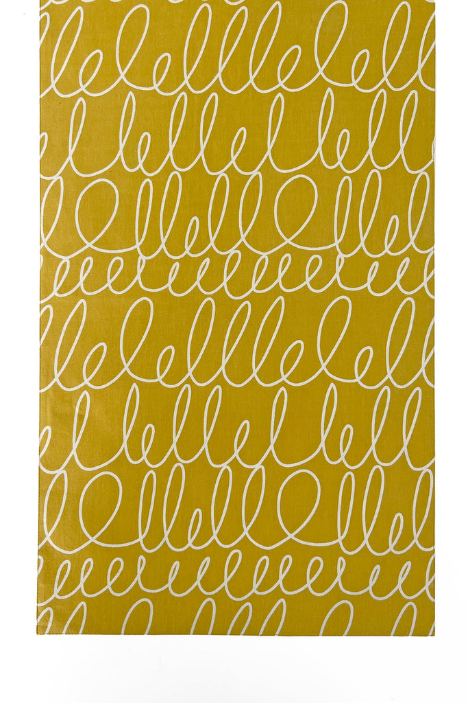 A yellow and white table runner with the word hello written on it, featuring vibrant prints and colors by See Design.