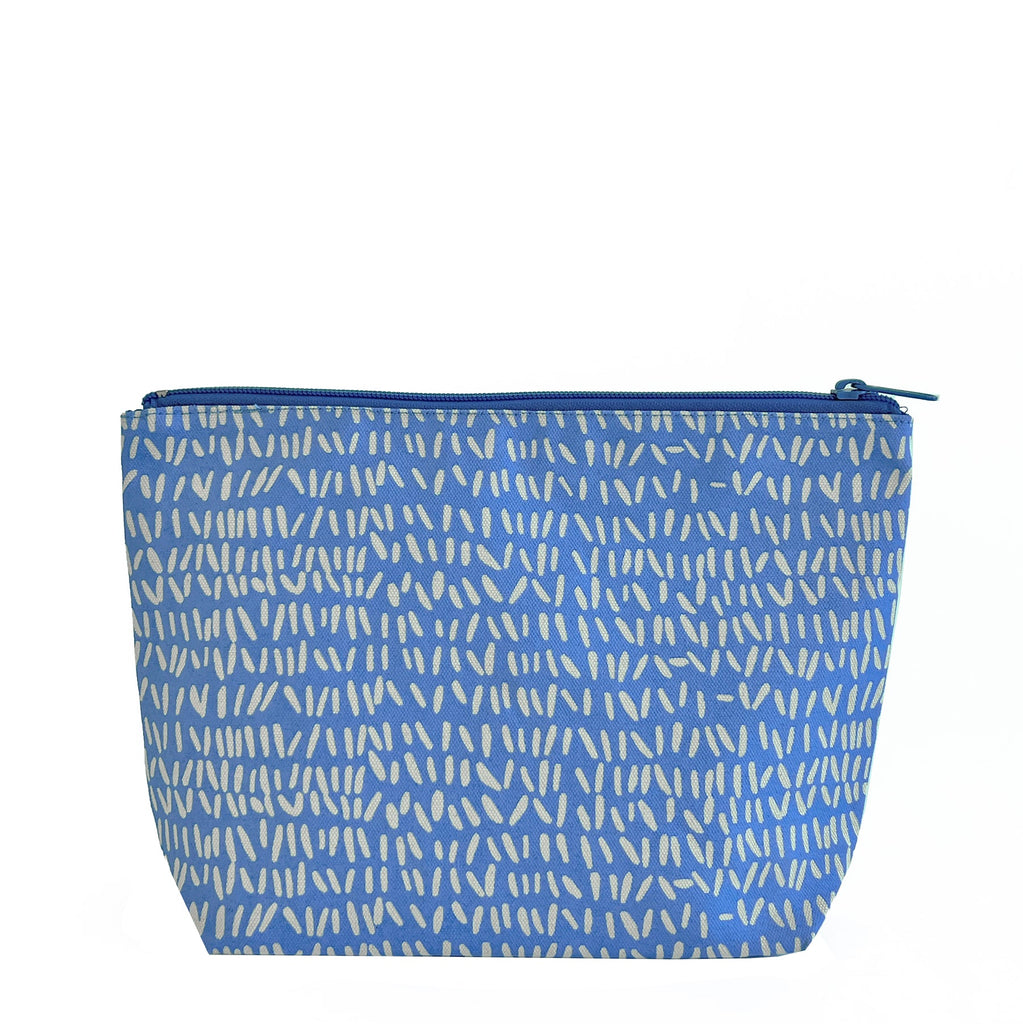 A large blue See Design Travel Pouch Large perfect for traveling with essential items.