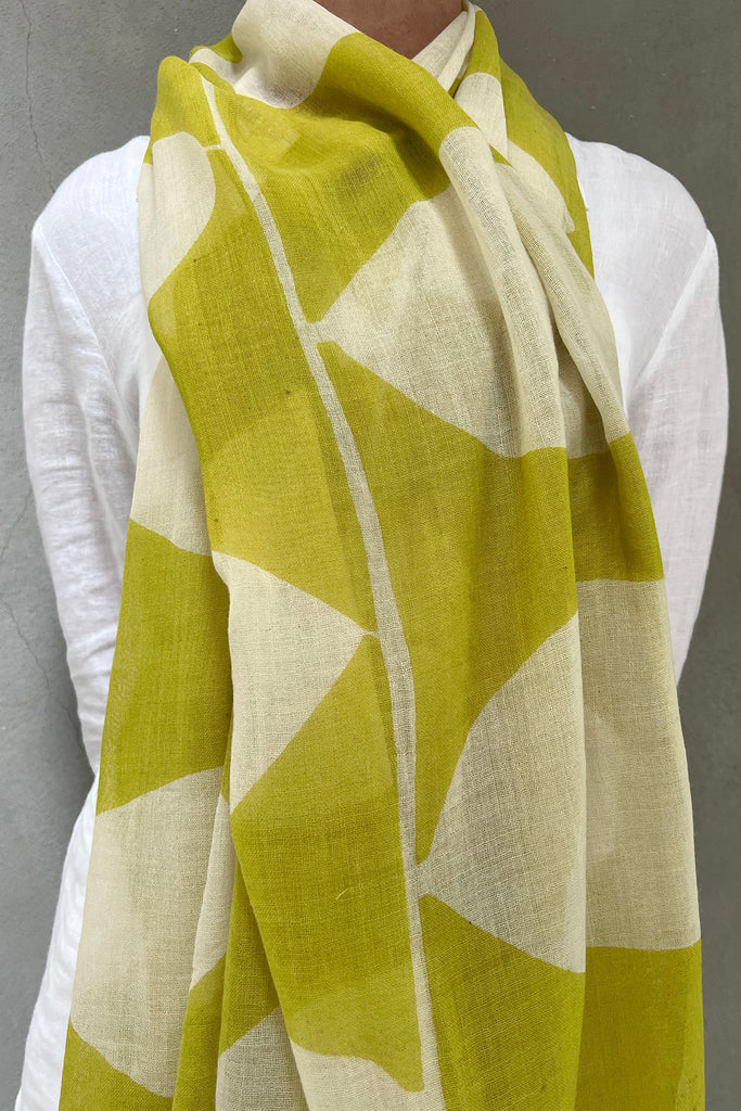 A woman wearing a bright green See Design wool scarf.