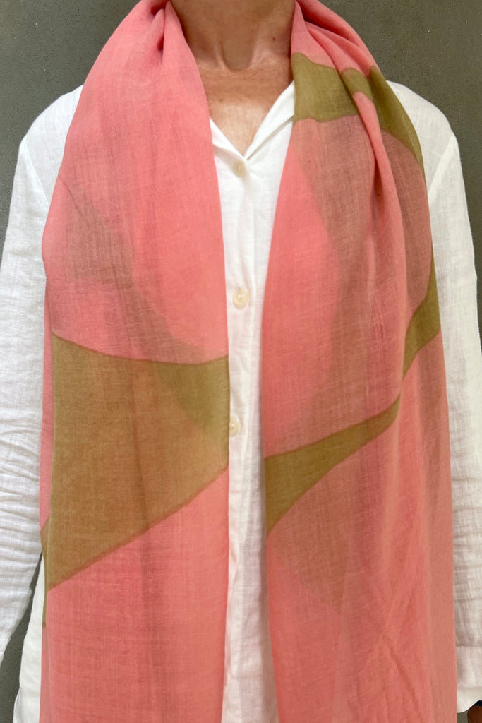 A woman wearing a pink See Design Wool Scarf.