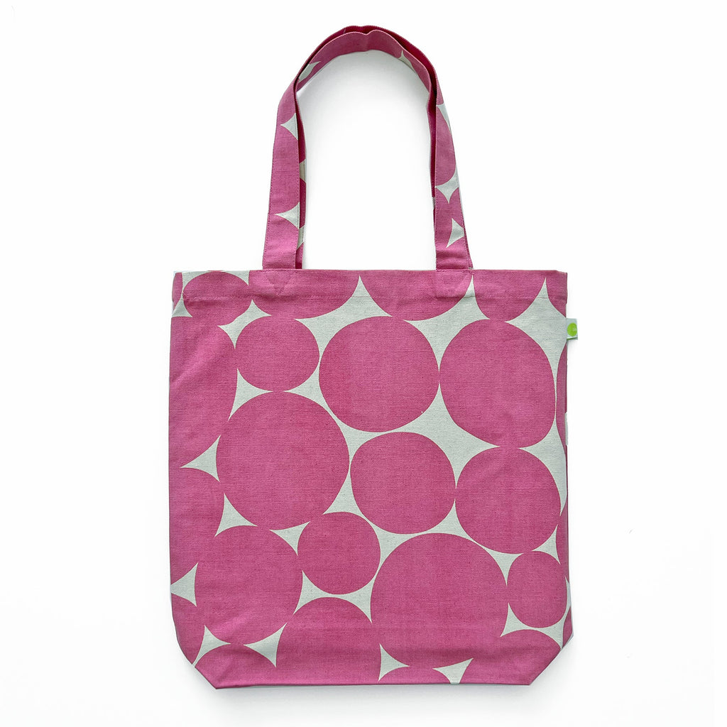 A lightweight Easy Tote Bag with hand-painted artwork, featuring pink and white polka dots by See Design.