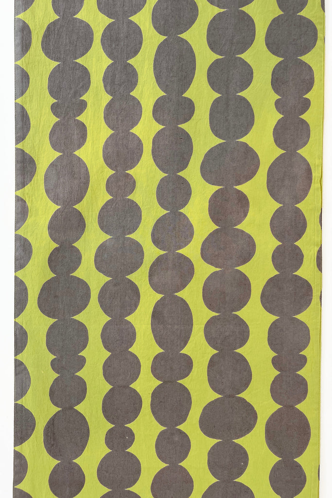 A yellow and grey table runner with dots on it, perfect for coordinating napkins by See Design.