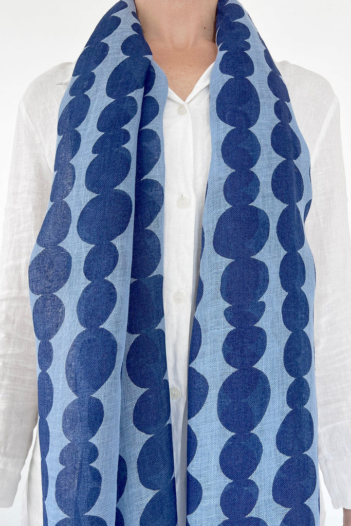 A modern design element is incorporated in a woman's attire as she wears a See Design linen scarf.