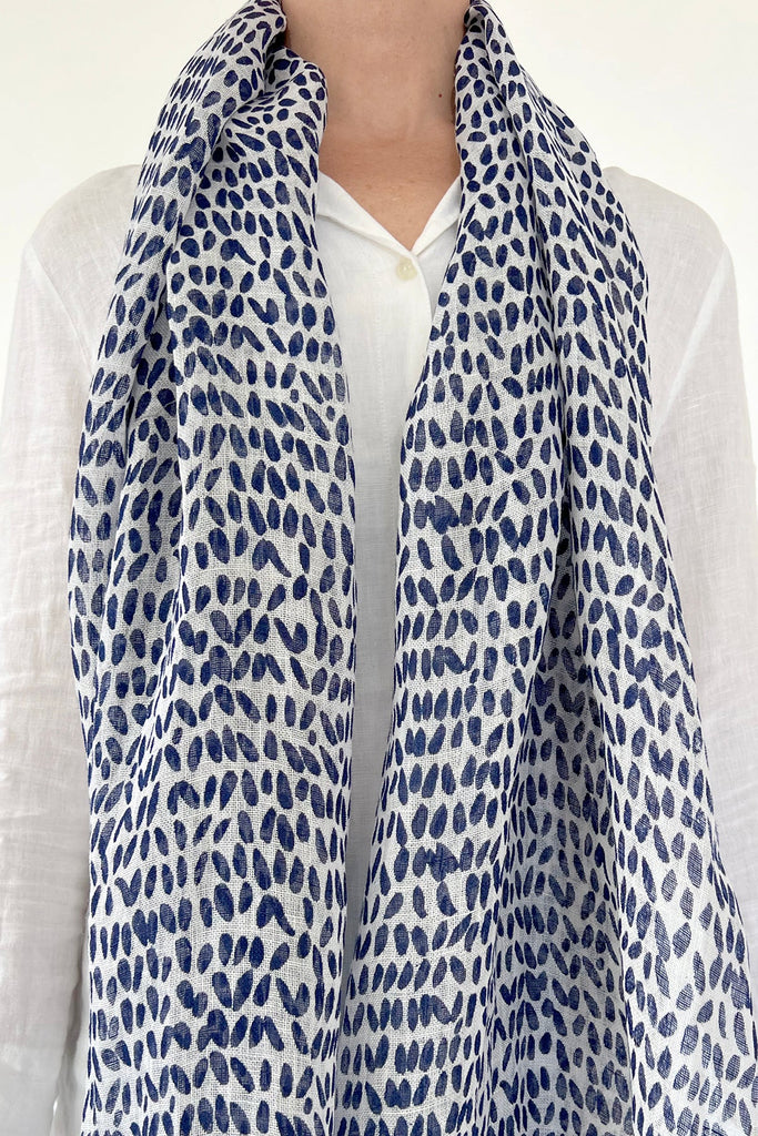 A modern design element in the form of a woman wearing a See Design Linen Scarf.