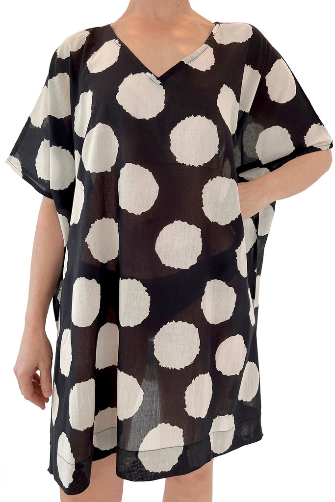 A lightweight woman wearing a black and white polka dot cotton Caftan by See Design.