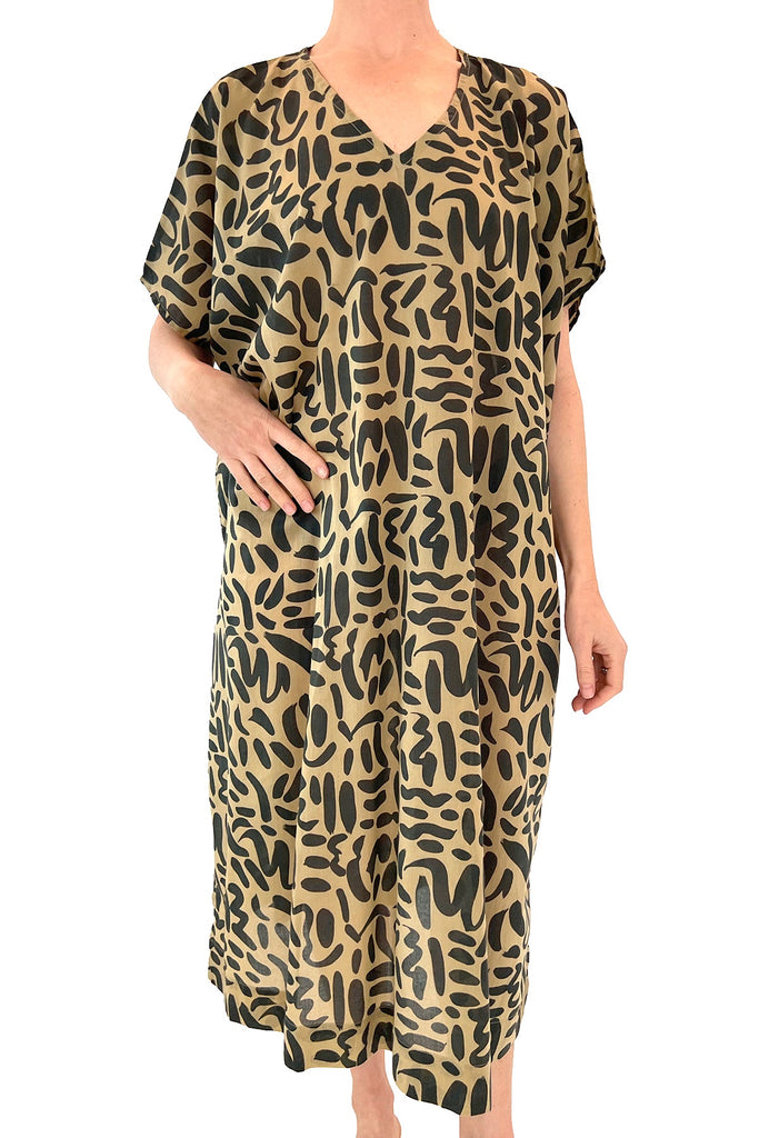 A woman wearing a comfortable See Design animal print Caftan Long dress, perfect as a beach cover up or lounge piece.
