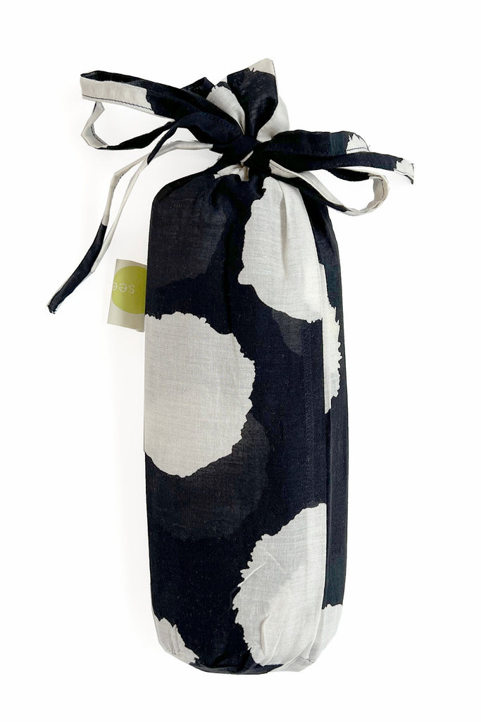 A fashionable Sarong bag from See Design, featuring black and white polka dots on a white background.
