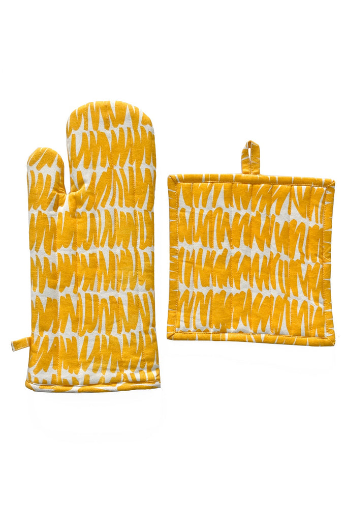 A yellow and white See Design oven mitt and potholder set with hand painted designs.