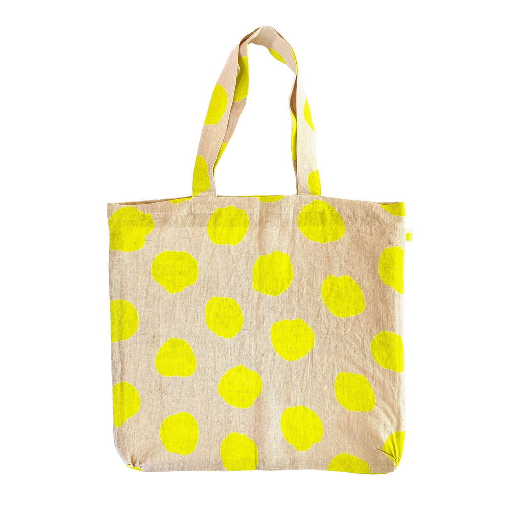 A sturdy yellow polka dot Linen Everyday Tote Bag by See Design, perfect for shopping.