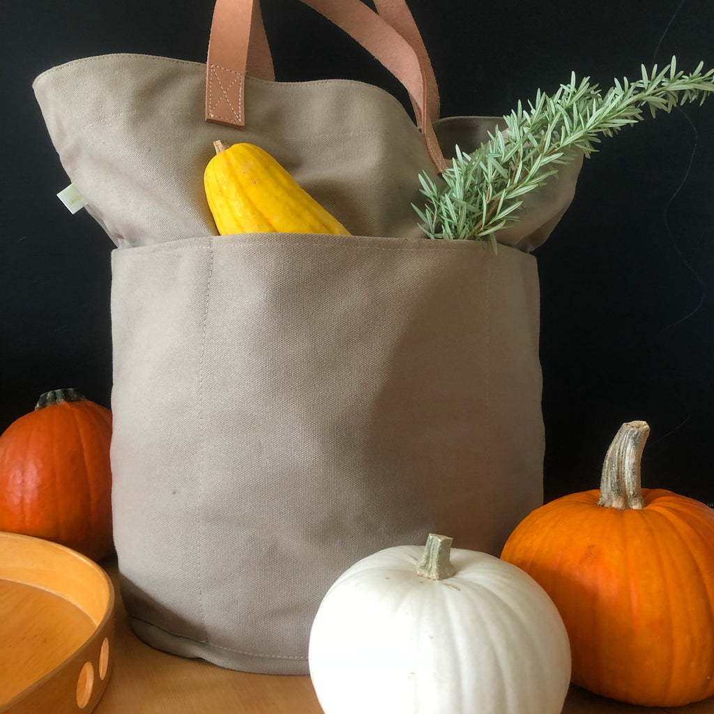 A See Design Tall Circle Tote with pumpkins and squash on a table.