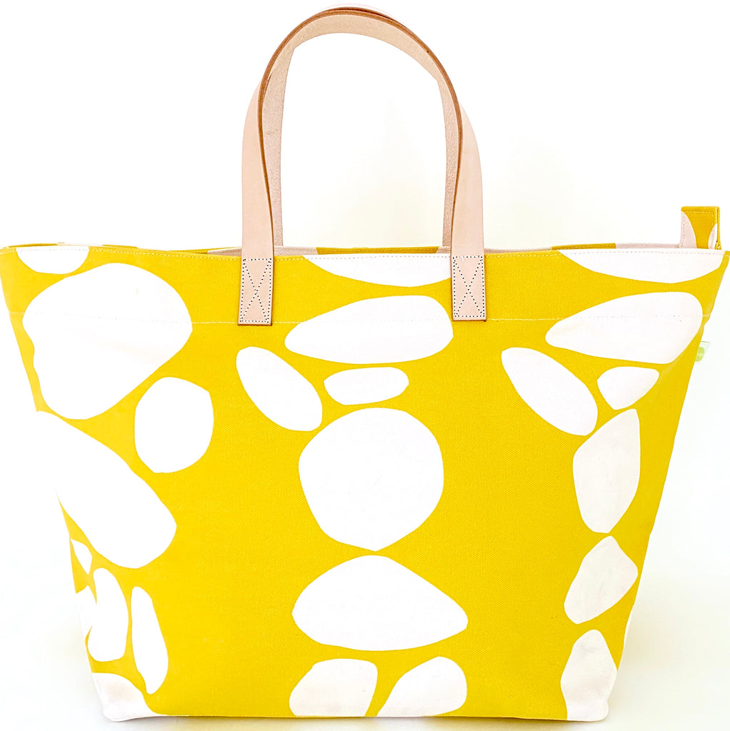 A yellow See Design Overnighter tote bag with white dots perfect for a weekend away.