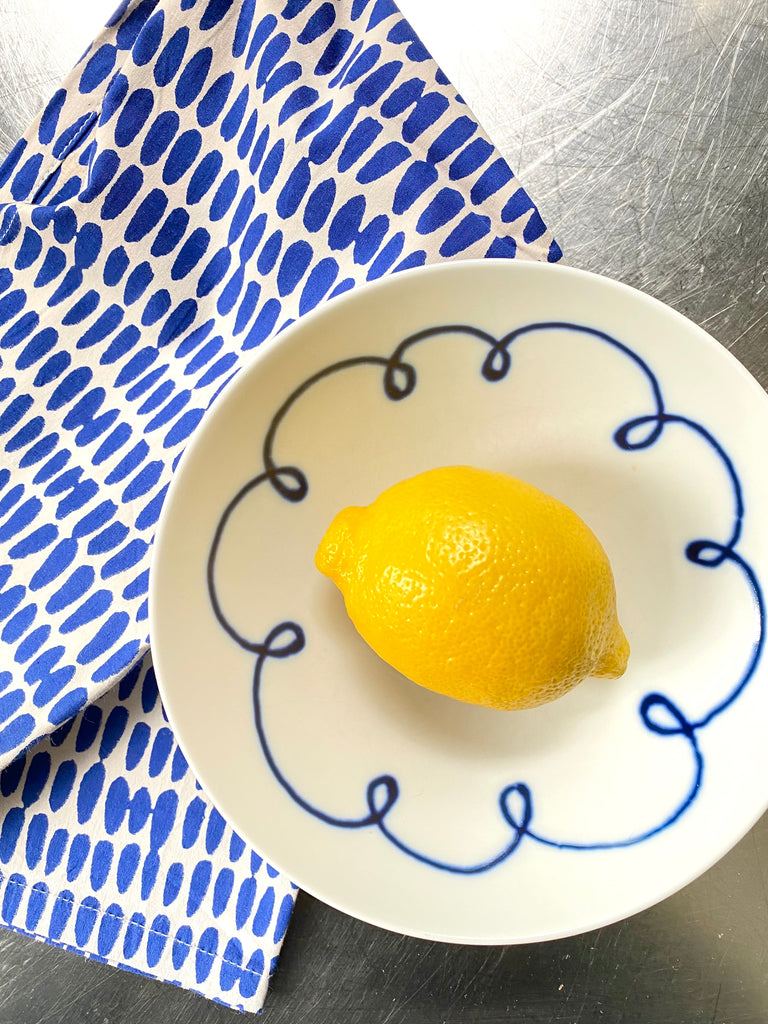 A hand-painted blue and white plate with a lemon on it was replaced by a set of 4 Napkins from the brand See Design.