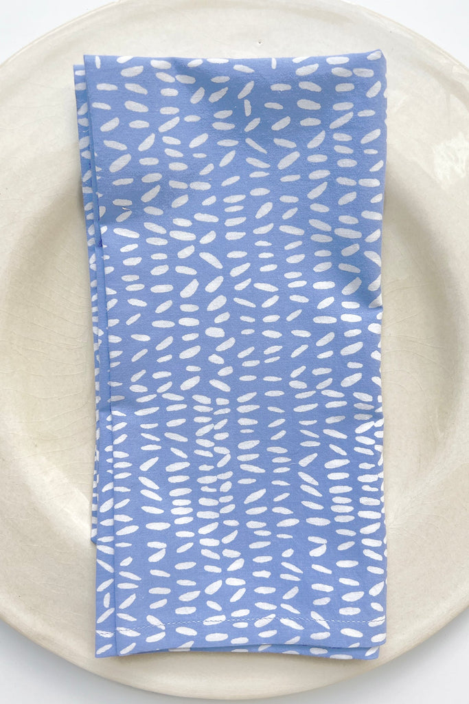 A set of 4 See Design napkins on a plate.
