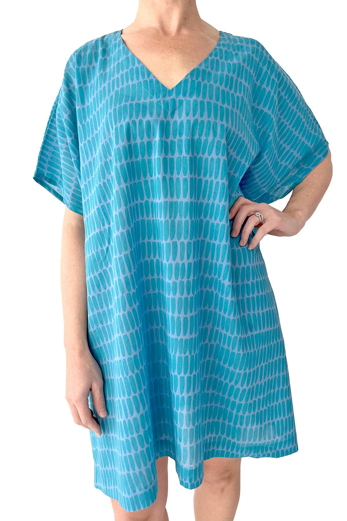 A woman wearing a stylish See Design caftan dress for a beach day.