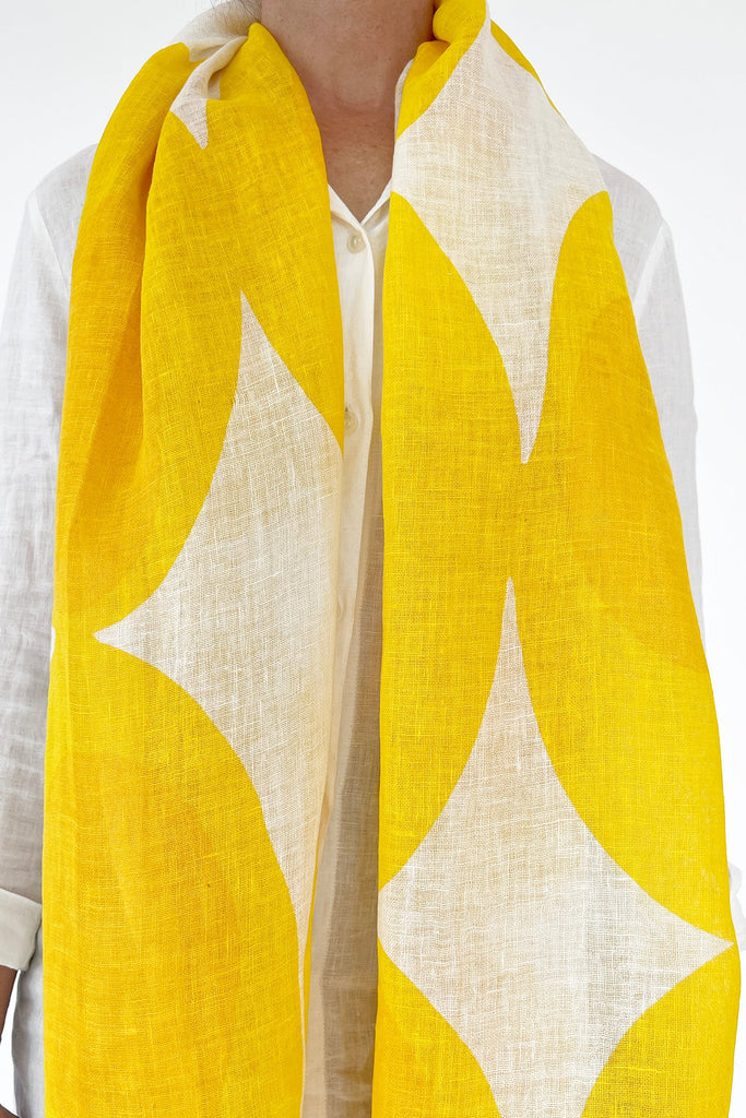 A woman is wearing a See Design linen scarf.