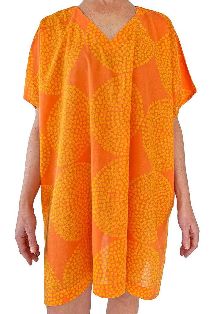 A woman wearing a stylish See Design orange caftan.