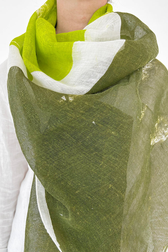 A woman wearing a See Design Linen Scarf, lightweight, green and white.