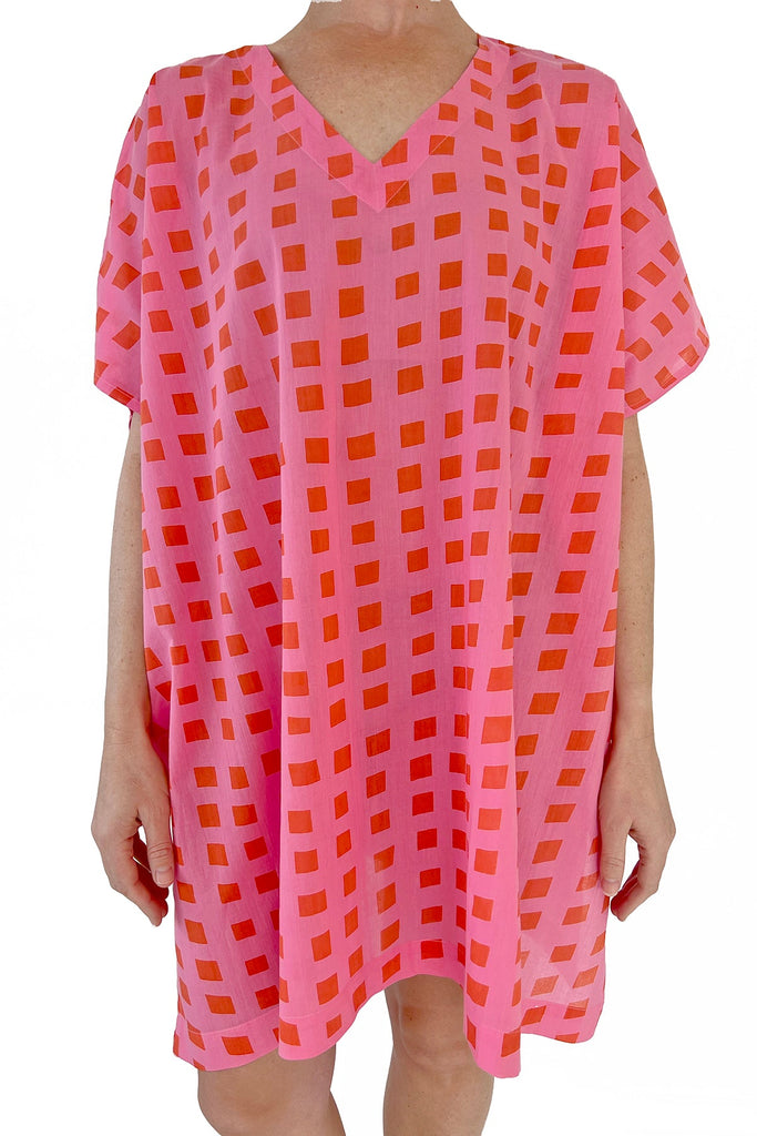 A woman wearing a stylish See Design caftan in bright colors.