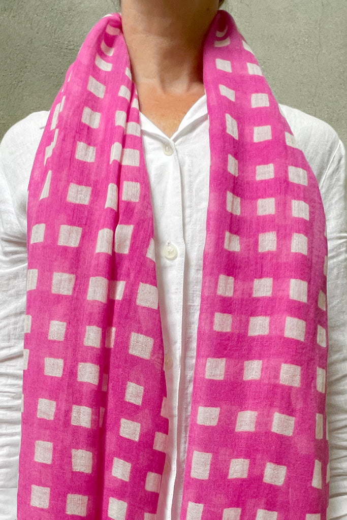 A woman wearing a See Design wool scarf with bright colors.