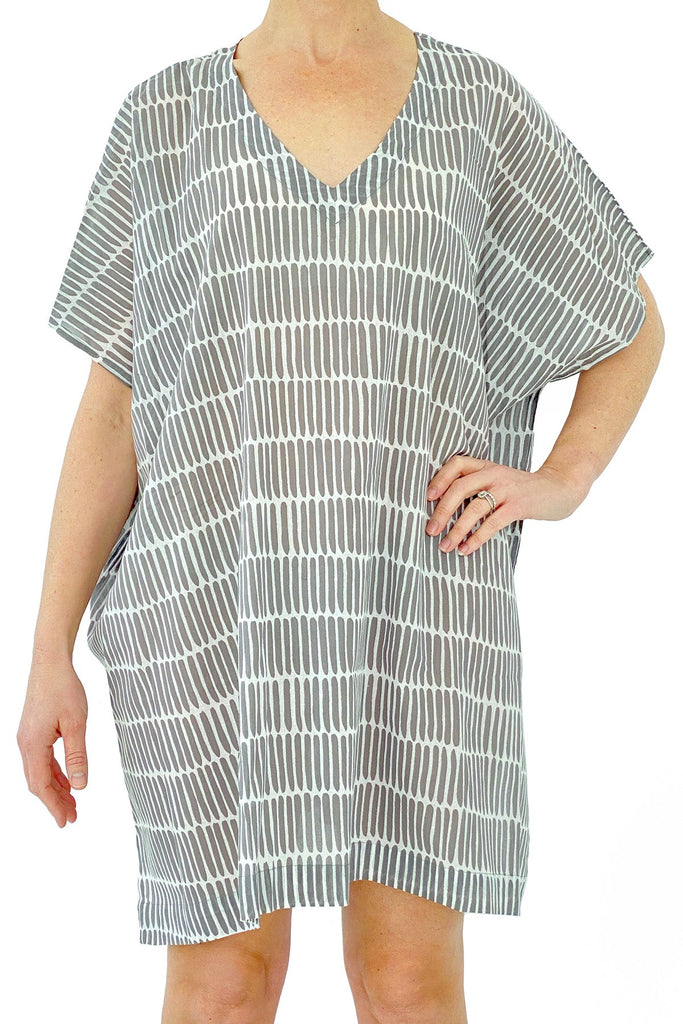 A woman wearing a lightweight See Design striped caftan dress.