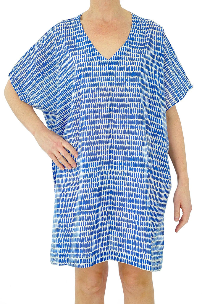 A woman wearing a blue and white cotton See Design caftan dress.