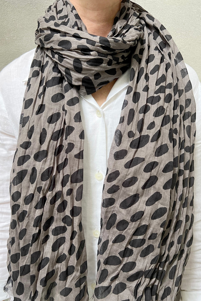 A woman wearing a See Design lightweight cotton scarf.