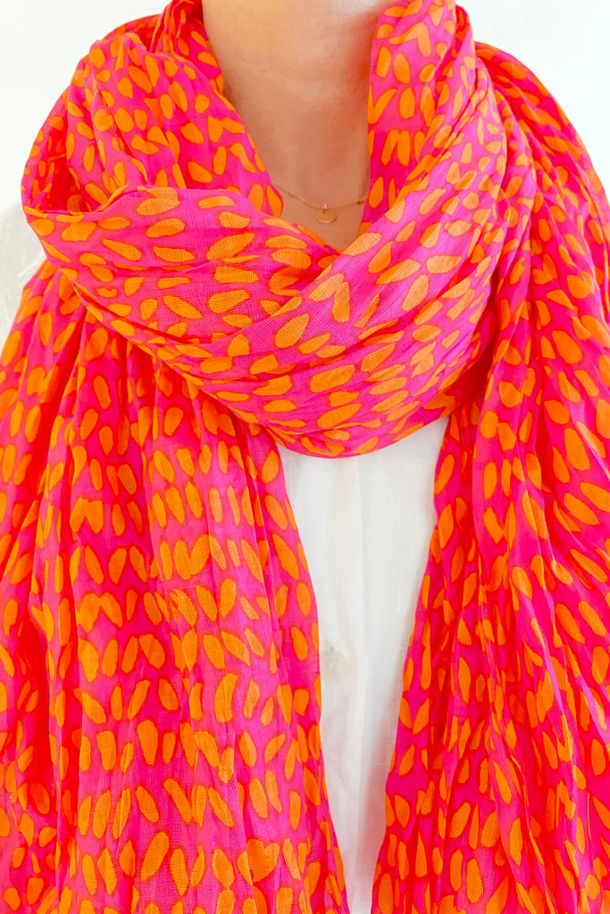 A woman wearing a lightweight pink Cotton Scarf by See Design.