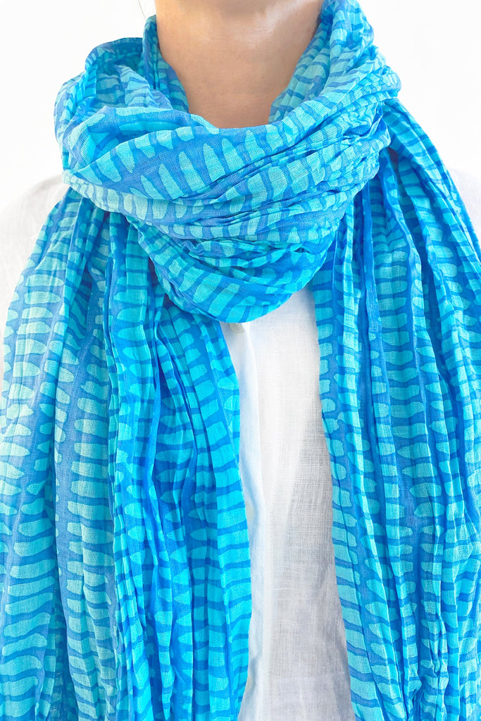 A woman wearing a delicately crinkled See Design cotton scarf.