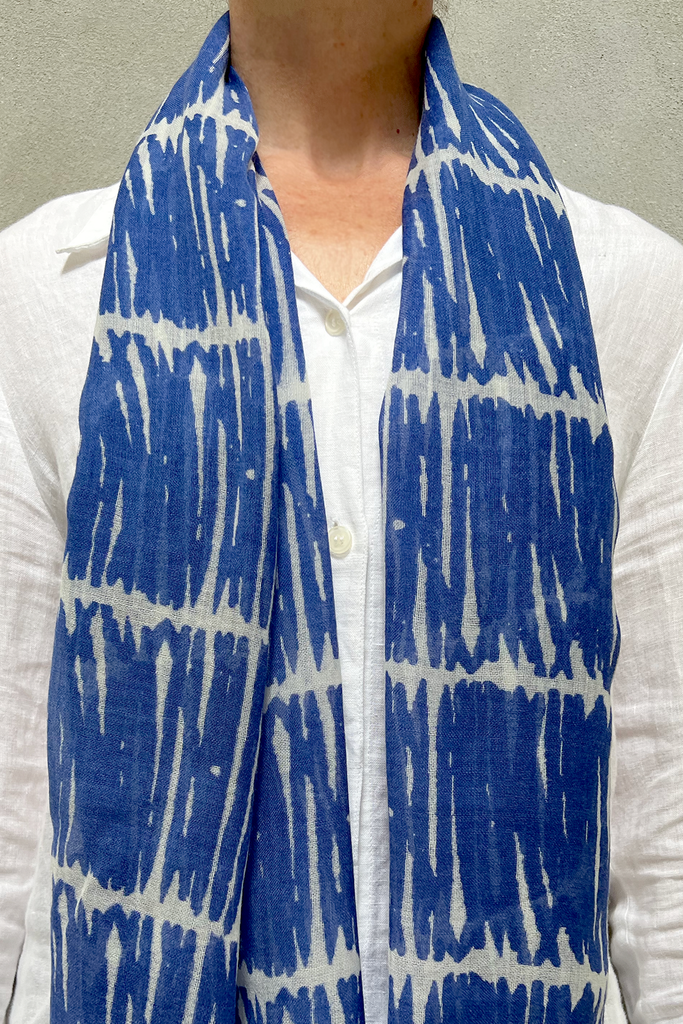 A woman wearing a bright blue and white See Design wool scarf.