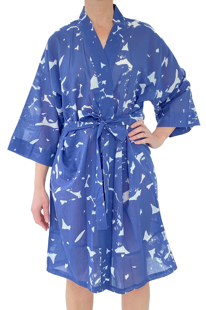 A woman wearing a lightweight blue and white print cotton voile See Design Kimono robe.