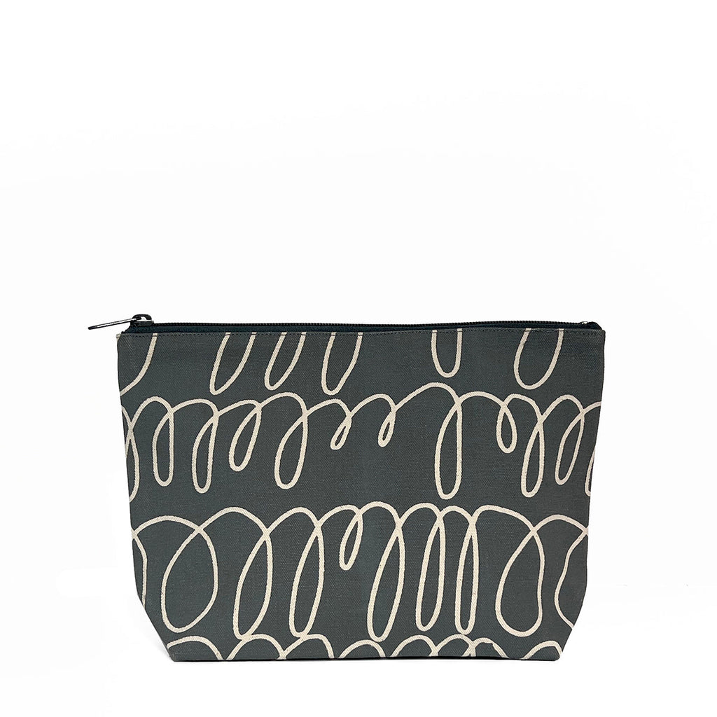 A black and white See Design Travel Pouch Large for passport and phone chargers.