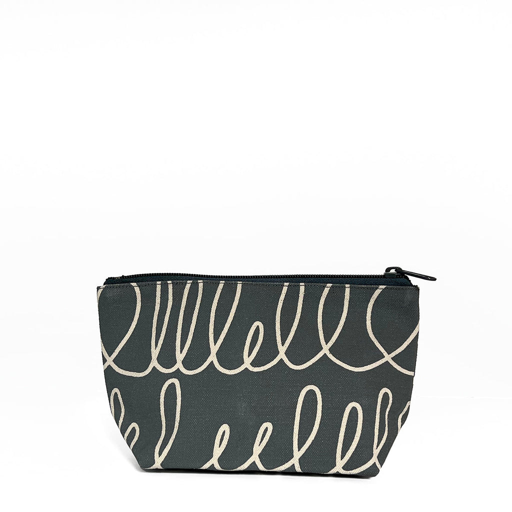 A small black and white See Design Travel Pouch Small for essential items.