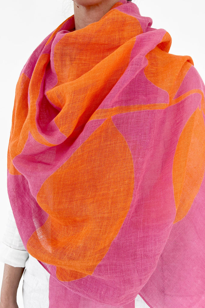A woman wearing a See Design linen scarf with colorful patterns.