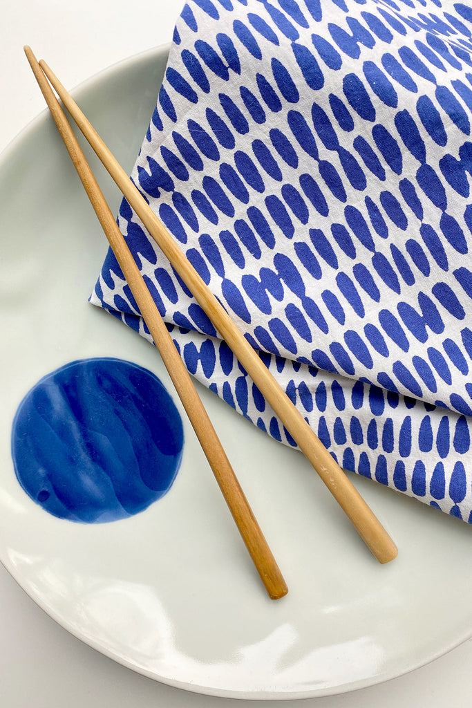 Blue and white chopsticks on a white plate with See Design napkins (Set of 4).
