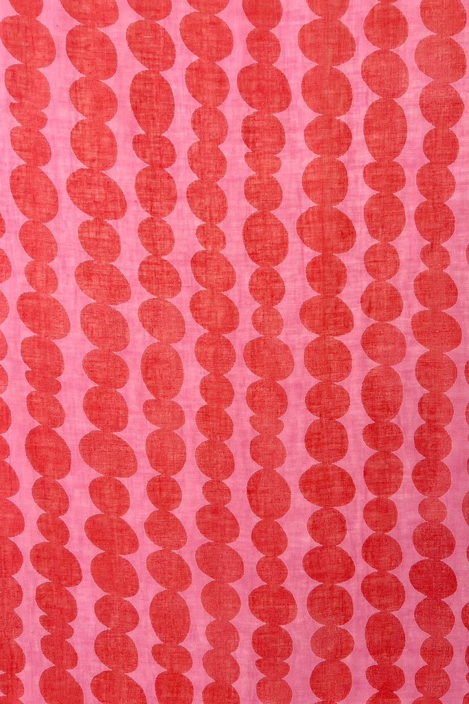 A close up of a See Design linen scarf with colorful patterns.