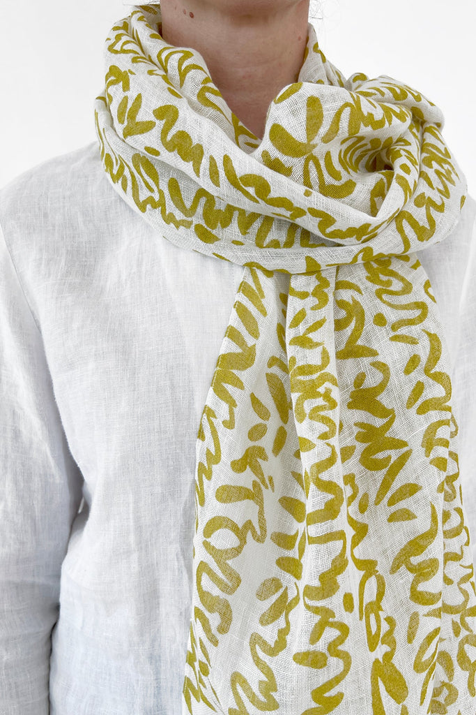 A woman wearing a colorful See Design linen scarf.