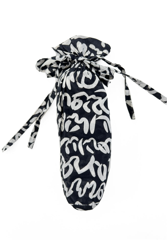 A fashionable See Design sarong bag in black and white, with a bow on it.