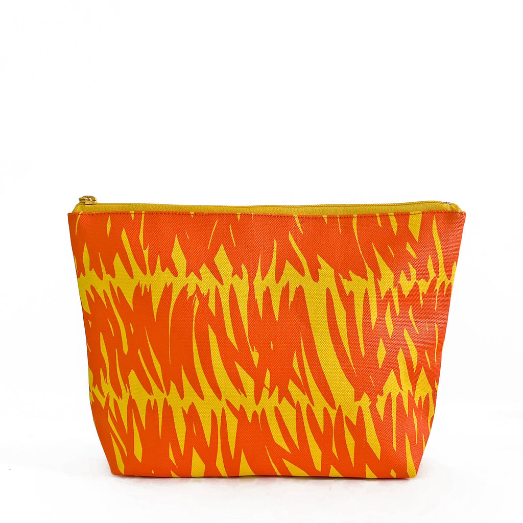 An essential See Design Travel Pouch Large with a vibrant orange and yellow zebra print.