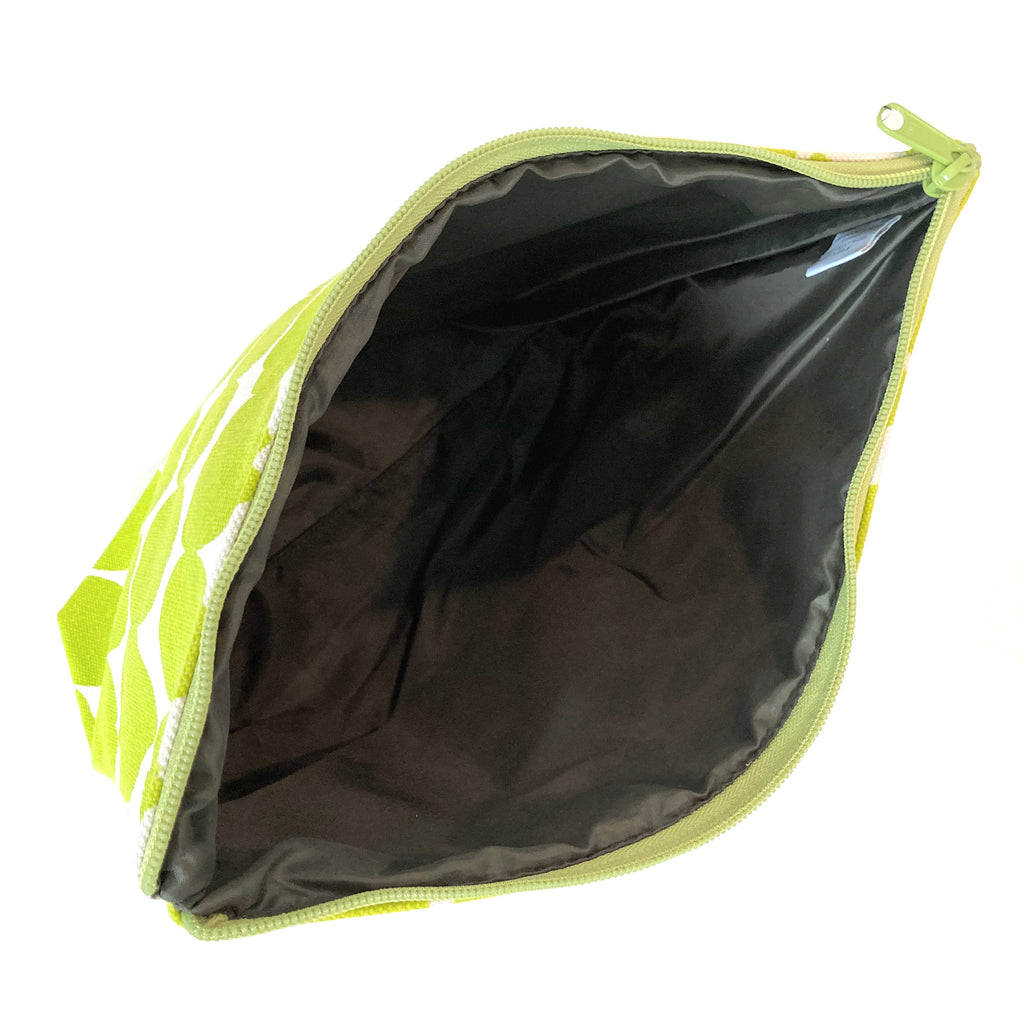 A green and black zippered Travel Pouch Extra Large from See Design on a white background.