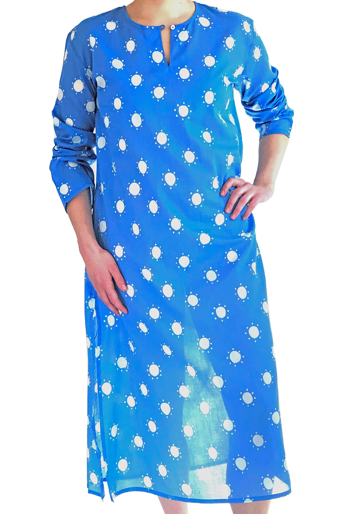 A woman wearing a See Design full length tunic made of lightweight and soft cotton voile, with white polka dots on a blue kurta.