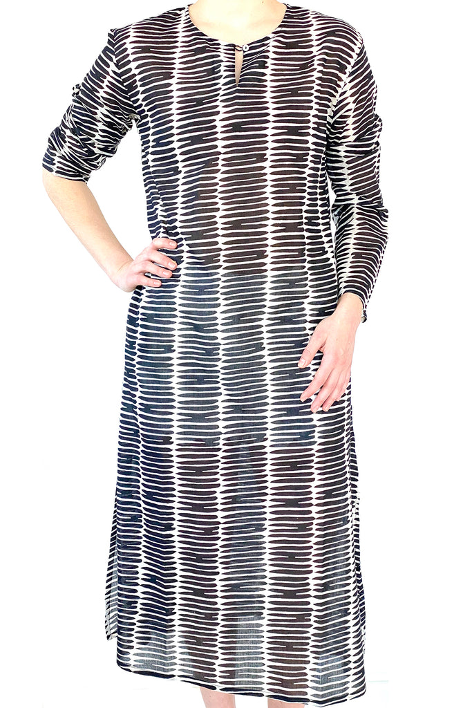 A woman wearing a See Design lightweight black and white striped Tunic Full Length dress.