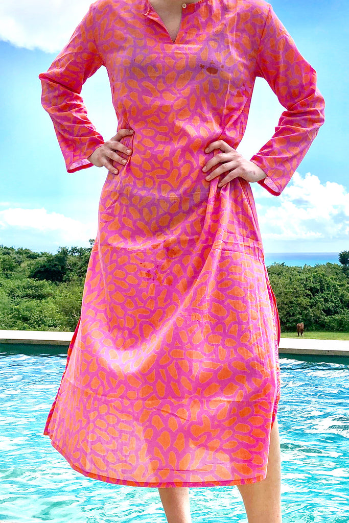 A woman wearing a See Design lightweight pink Tunic Full Length standing next to a pool.