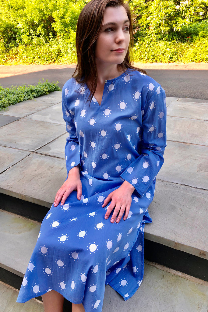 A woman in a lightweight and soft, See Design Tunic Full Length dress sitting on steps.